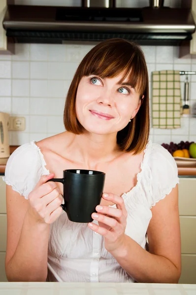 年轻女人，享受一杯咖啡在她家中. — 图库照片