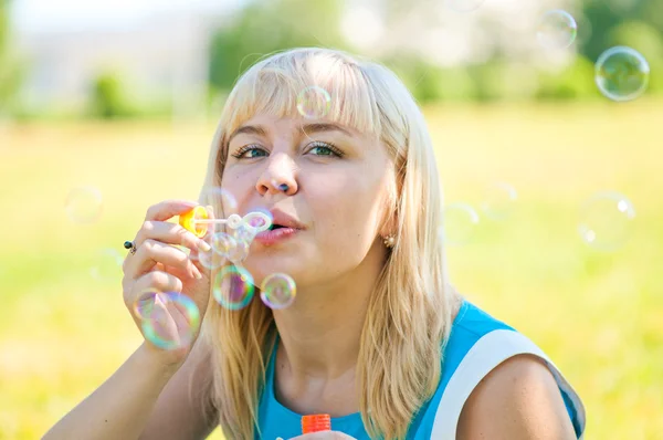 Frau pustet Blasen in Park — Stockfoto