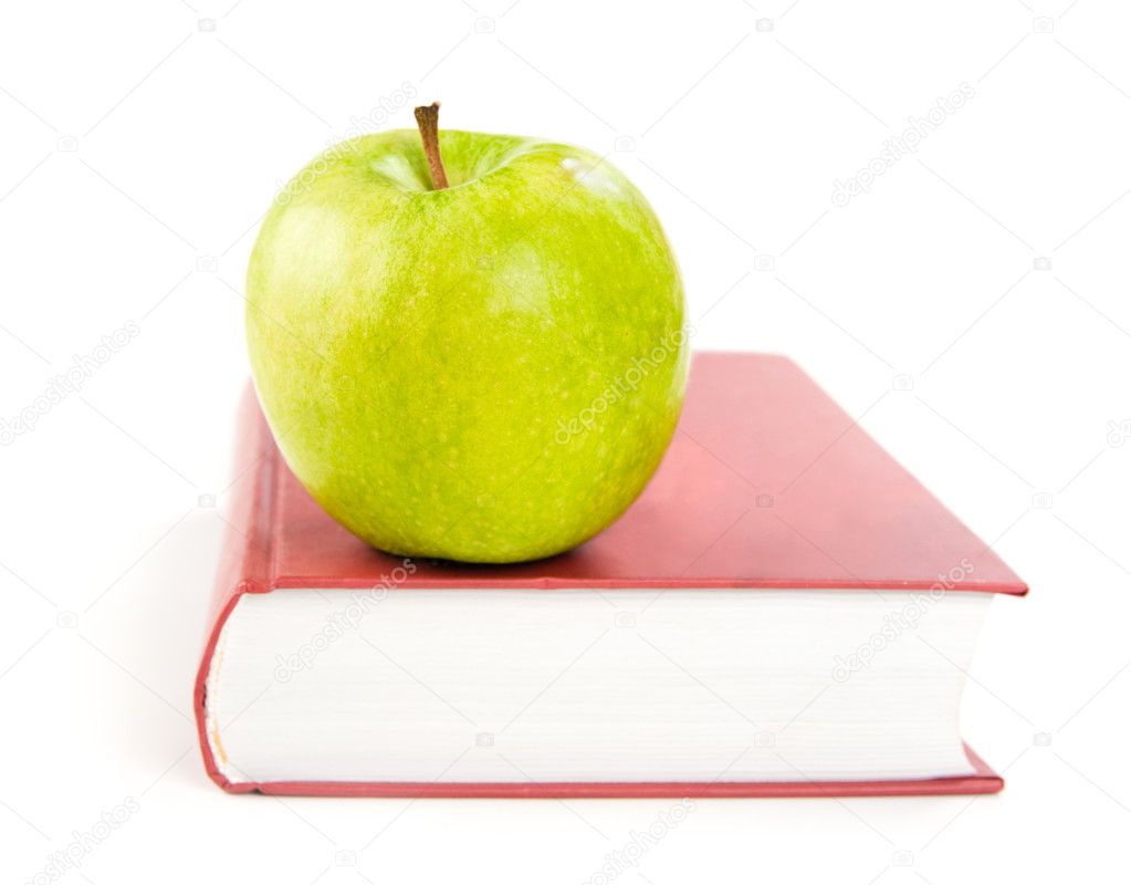 A green apple on a book