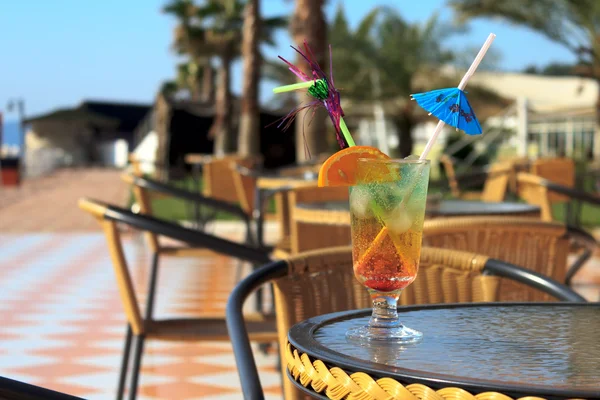 Colorful cocktail with umbrella and slice of orange — Stock Photo, Image