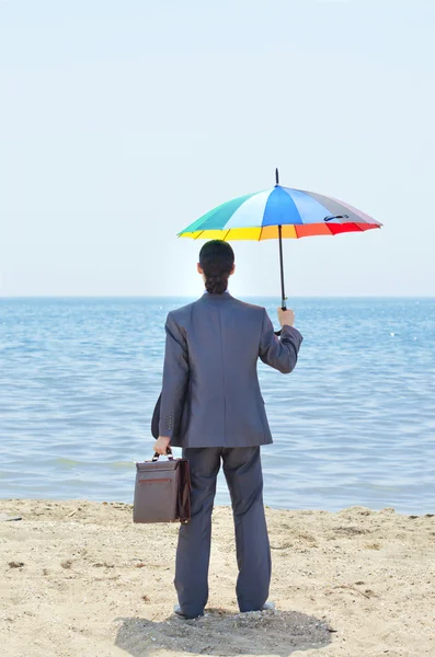 Man met paraplu op strand — Stockfoto