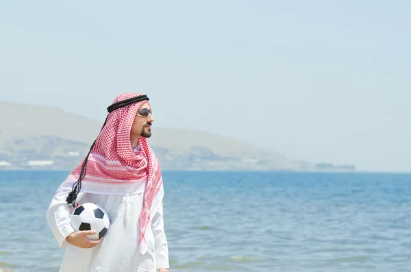 Араб с футболом на берегу моря — стоковое фото