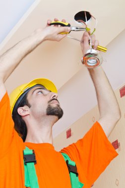 Electrician working on cabling lighting clipart