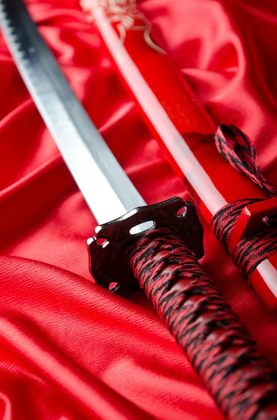 Japonês takana espada no fundo de cetim vermelho — Fotografia de Stock