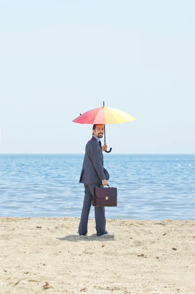 Mann mit Sonnenschirm am Strand — Stockfoto
