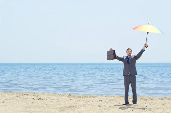 Muž s deštníkem na pláži — Stock fotografie