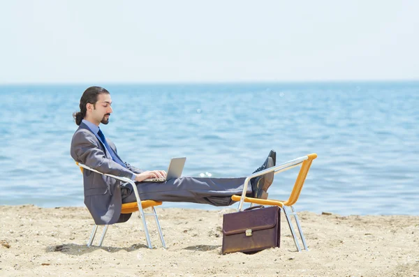 stock image Businessman working on laptop on seaside