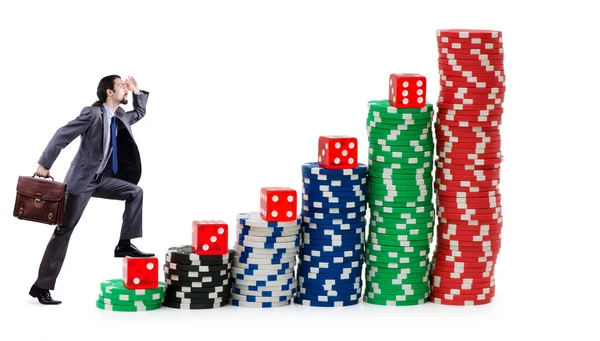 Бизнесмен лазает по стопкам фишек казино — стоковое фото
