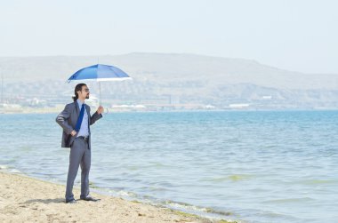 Man with umbrella on seaside beach