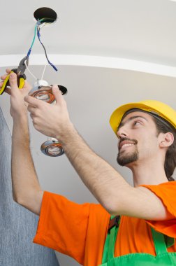 Electrician repairman working on refurbishment clipart