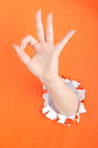 Mão fora do furo de papel — Fotografia de Stock