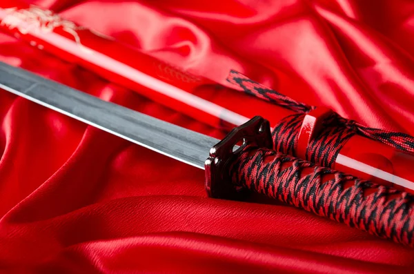 stock image Japanese sword takana on red satin background