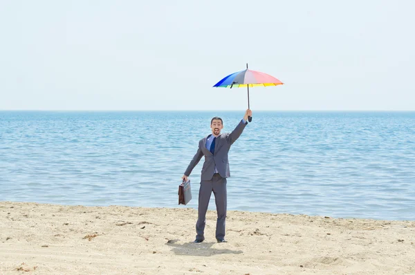 Man met paraplu op strand — Stockfoto