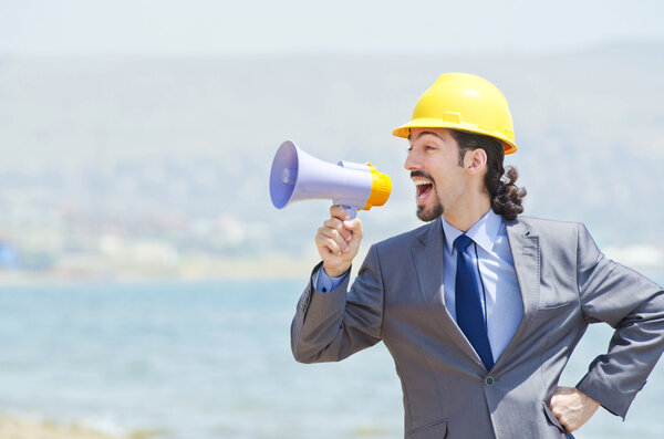 Man wearing helmet speaks with megaphone
