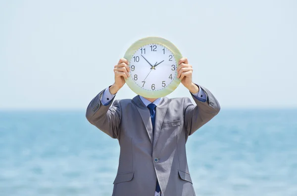 海辺に時計を持つ男 ストック画像