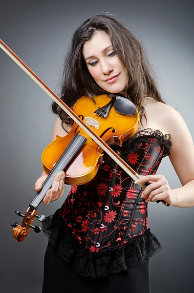Vrouwelijke viool speler tegen achtergrond — Stockfoto
