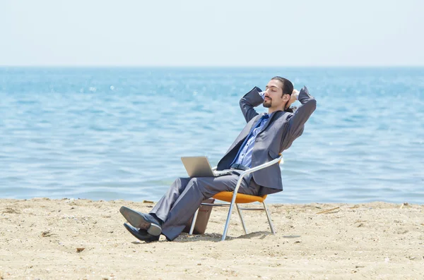 stock image Businessman working on laptop on seaside