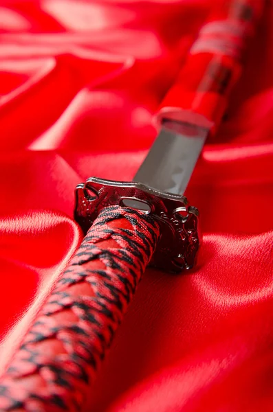 Spada giapponese takana su sfondo raso rosso — Foto Stock