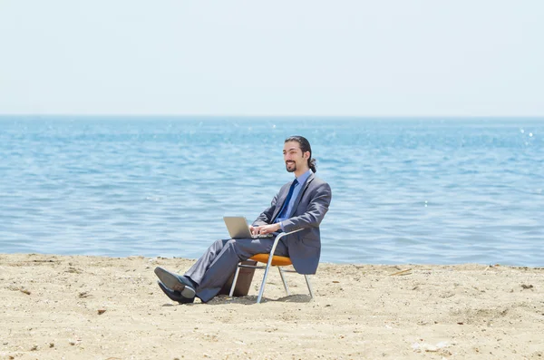 stock image Businessman working on laptop on seaside