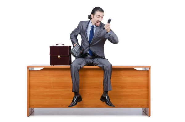 Бізнесмен сидить на столі і розмовляє телефоном — стокове фото