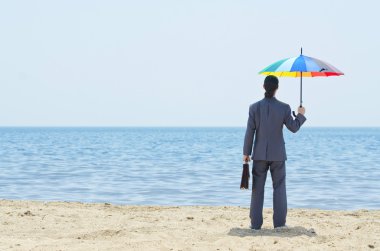 Man with umbrella on beach clipart