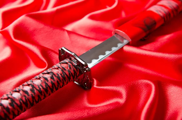 Japanisches Schwert Takana auf rotem Satin Hintergrund — Stockfoto