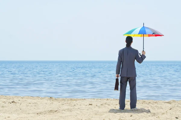 Человек с зонтиком на пляже — стоковое фото
