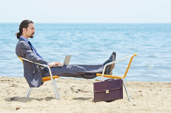 在海边的笔记本电脑上工作的生意人 — 图库照片