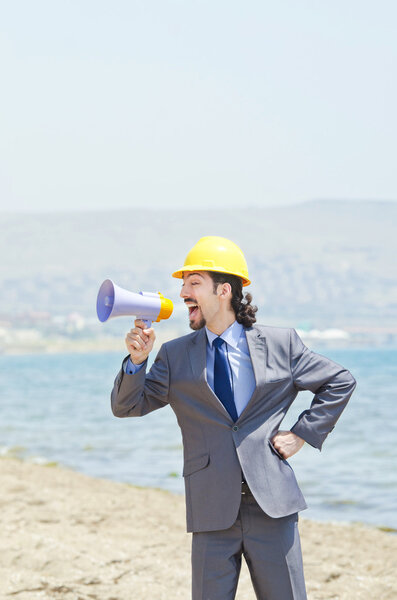 Man wearing helmet speaks with megaphone
