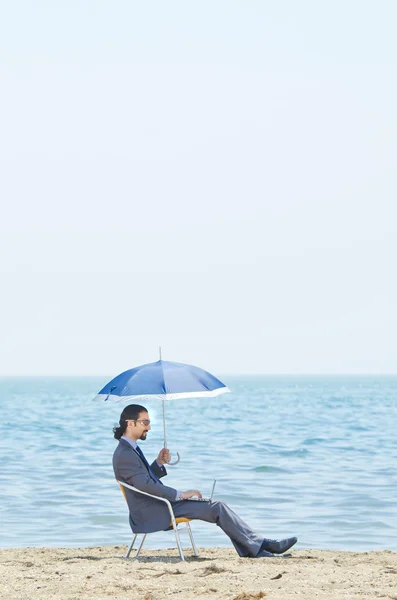 Człowiek z parasolem na plaży nad morzem — Zdjęcie stockowe