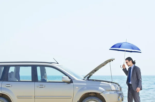 Человек с машиной на берегу моря — стоковое фото