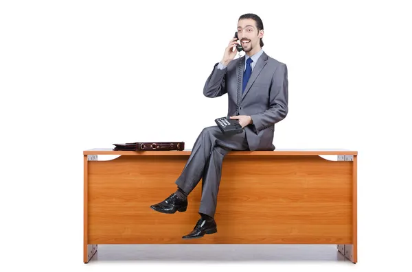 Бізнесмен сидить на столі і розмовляє телефоном — стокове фото