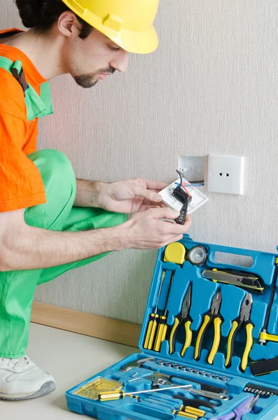 Electrician repairman working in the house Stock Image