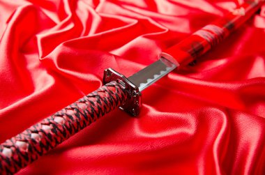 Japon kılıcı takana kırmızı saten zemin üzerine