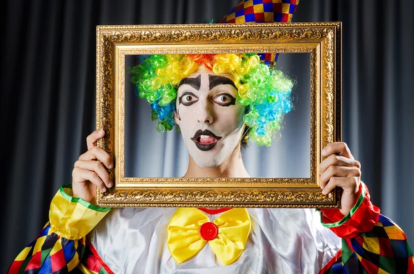 Clown with picture frames in studio — Stock Photo, Image