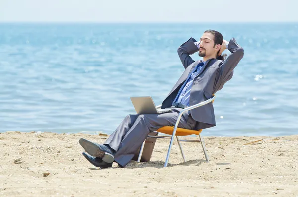 Empresario trabajando en el ordenador portátil en la playa — Foto de Stock
