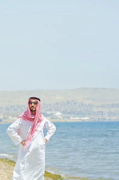Араб на берегу моря в традиционной одежде — стоковое фото