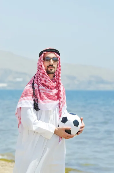 Arabische met footbal aan zee — Stockfoto