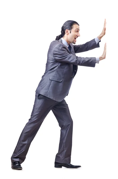 Young businessman pushing invisible obstacles — Stock Photo, Image