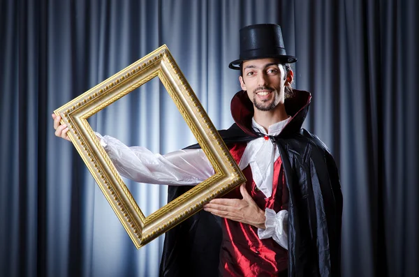Magicien avec cadre photo en studio — Photo