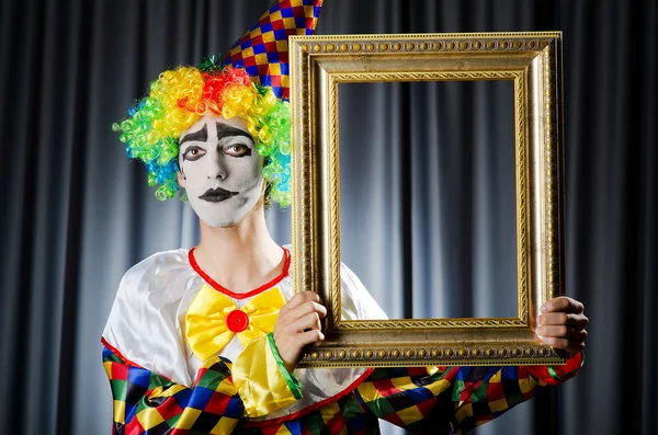 Clown with picture frames in studio — Stock Photo, Image