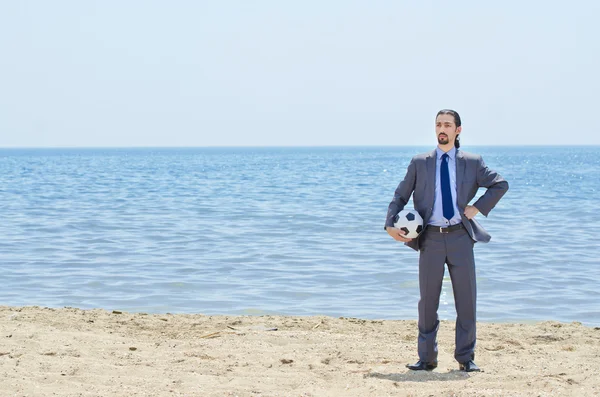 Businessman with football on beach — Stock Photo, Image