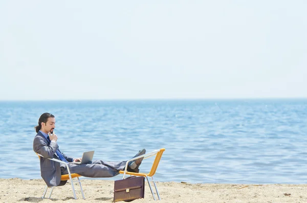 stock image Businessman working on laptop on seaside