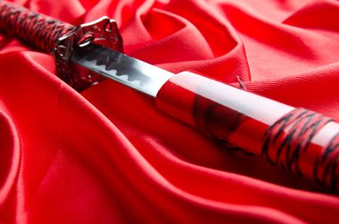 Japanese sword takana on red satin background clipart