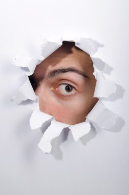 Male face through the hole in paper clipart