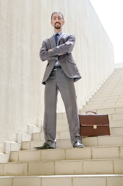 Empresário com escada no conceito de negócio — Fotografia de Stock