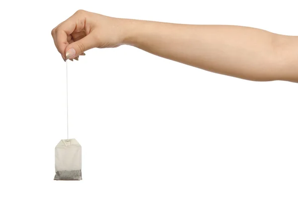 Mão segurando teabag no branco — Fotografia de Stock