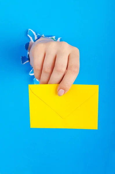 Hand holding paper envelope from hole — Stock Photo, Image
