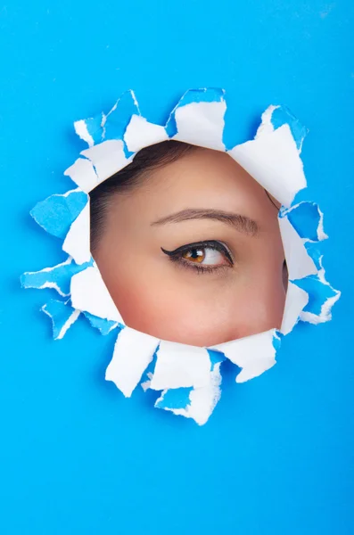 Female face through the hole in paper — Stock Photo, Image