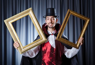 Magician with photoframe in studio clipart